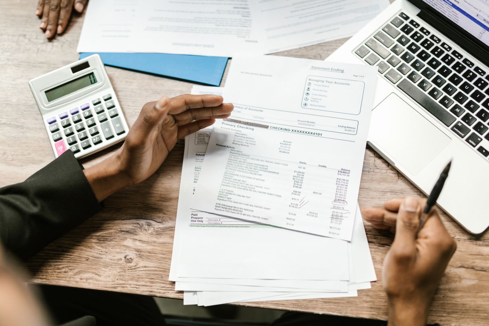 Documentos financieros junto a calculadora y portátil