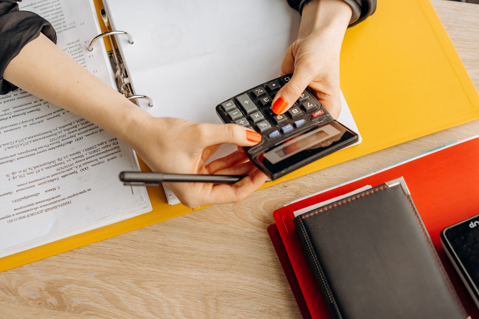 Manos usando una calculadora con documentos